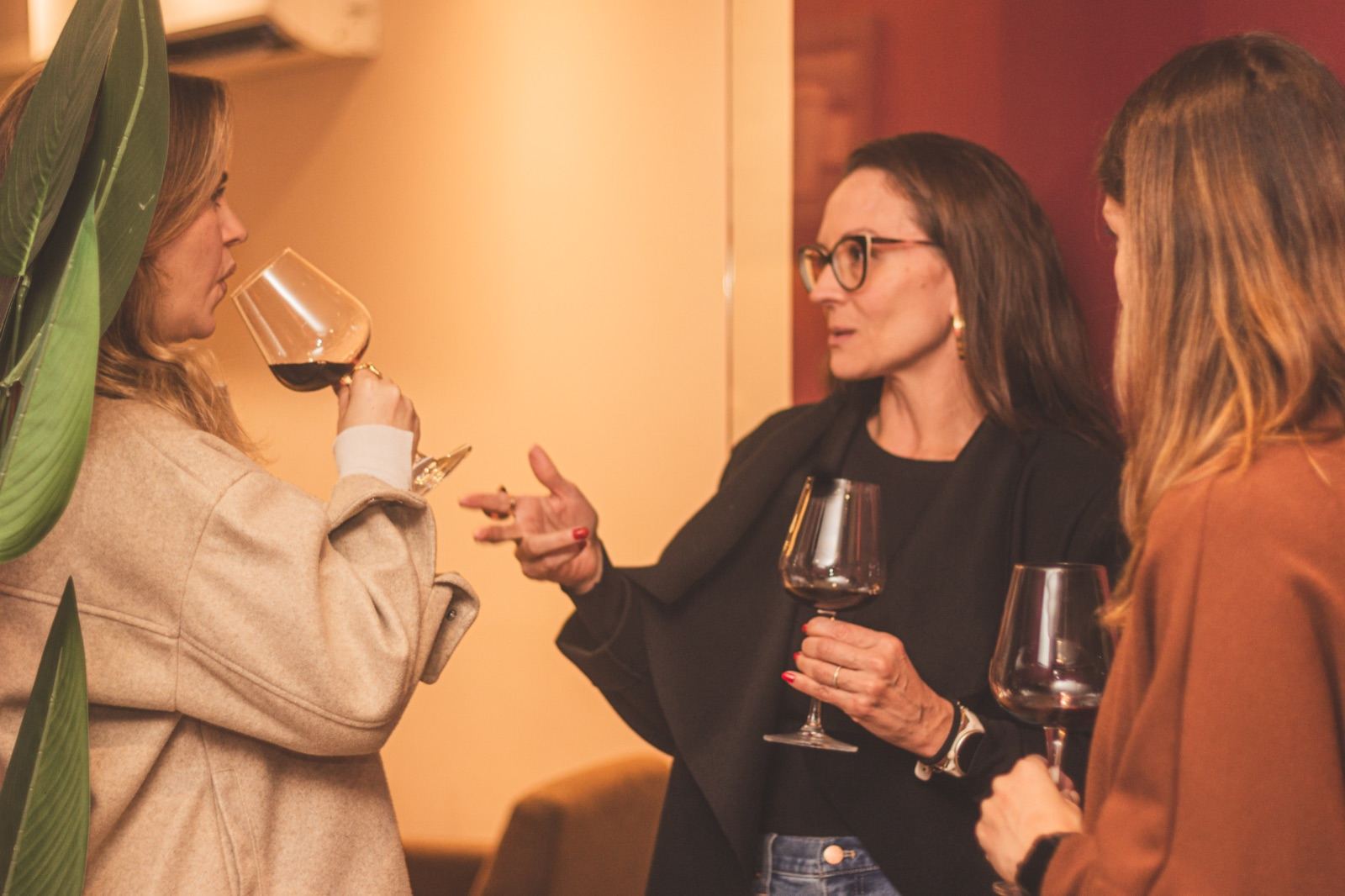 Participantes conversando com taças de vinho em um workshop da Claud.IA